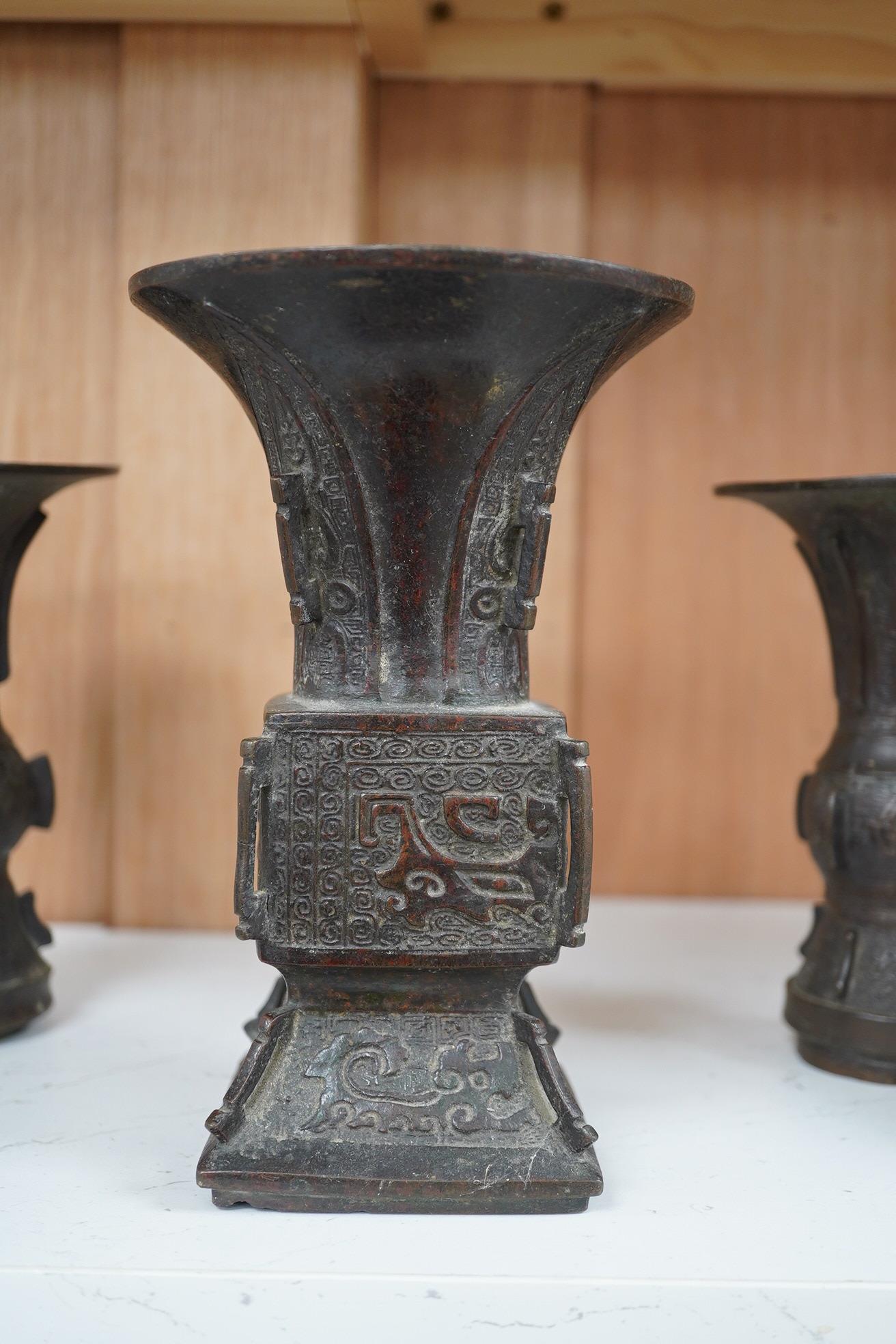 A pair 17th/18th century Chinese archaistic bronze gu vases, and a similar square vase, fanggu, Ming dynasty, tallest 18cm. Condition - poor to fair